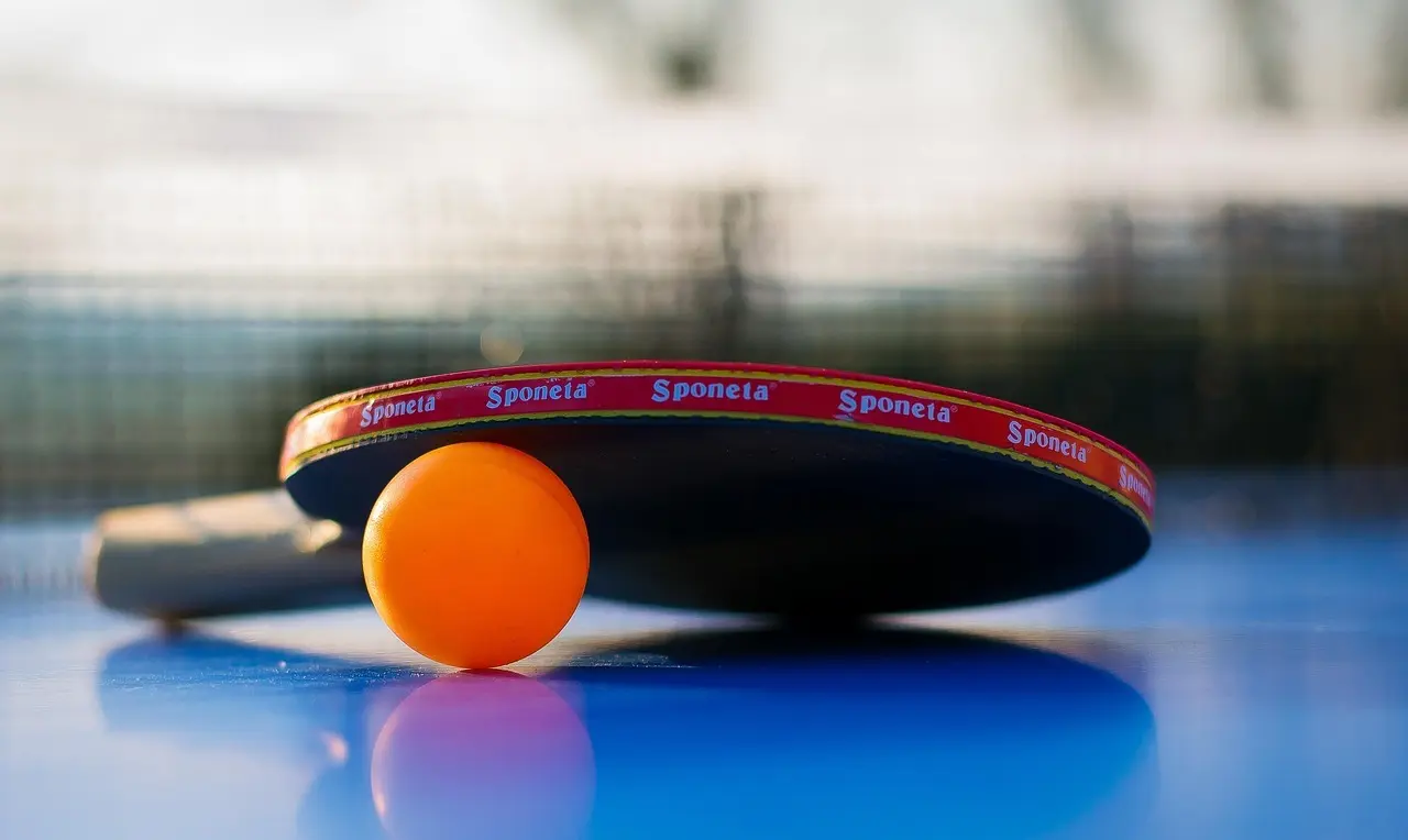 Bordtennisbat og orange bordtennisbold